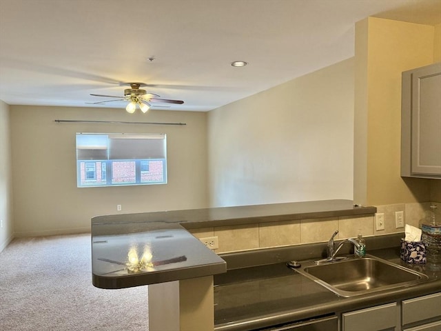 211 Central Unit A210, Norwood, MA 02062 - kitchen featuring a sink, dark countertops, ceiling fan, carpet, and baseboards