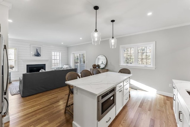 kitchen featuring a healthy amount of sunlight, white cabinets, and a kitchen bar