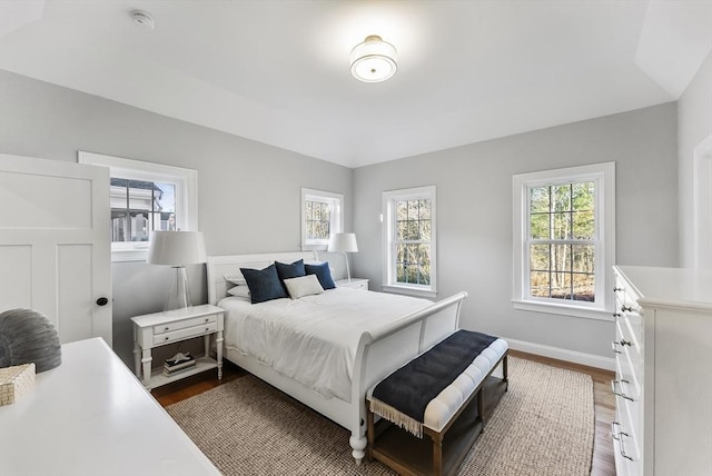 bedroom with dark wood-type flooring and baseboards