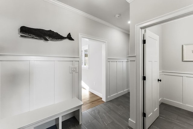 interior space with dark wood-type flooring, wainscoting, and ornamental molding