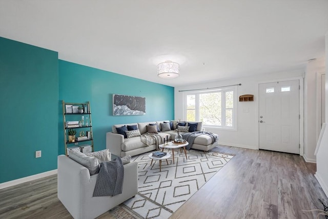 living area with baseboards and wood finished floors