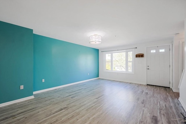 unfurnished living room featuring baseboards and wood finished floors