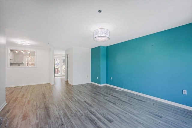 unfurnished living room featuring baseboards and wood finished floors