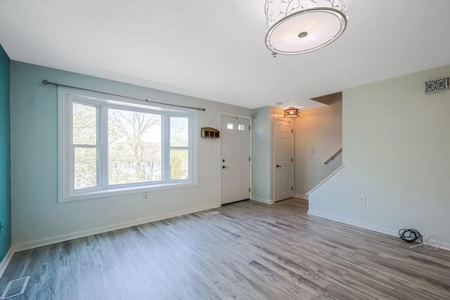 entrance foyer featuring baseboards, wood finished floors, and visible vents