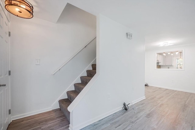 stairs featuring baseboards and wood finished floors