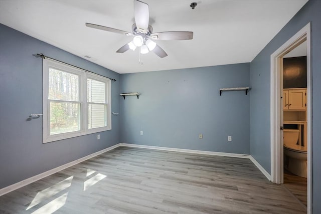 unfurnished bedroom with baseboards, a ceiling fan, wood finished floors, and visible vents