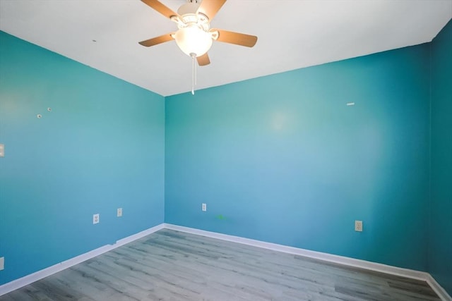 unfurnished room with baseboards, ceiling fan, and wood finished floors