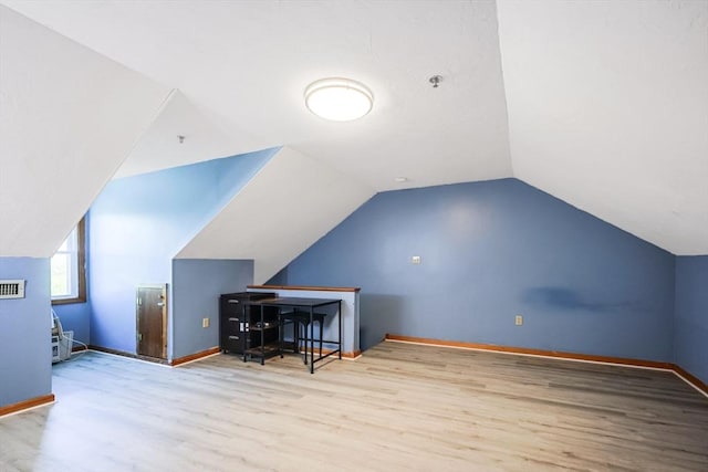 bonus room with baseboards, vaulted ceiling, wood finished floors, and visible vents