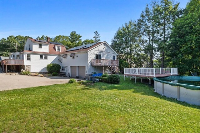 225 W Main St, Dudley, MA 01571 - rear view of property with stairway, a wooden deck, a garage, driveway, and a covered pool