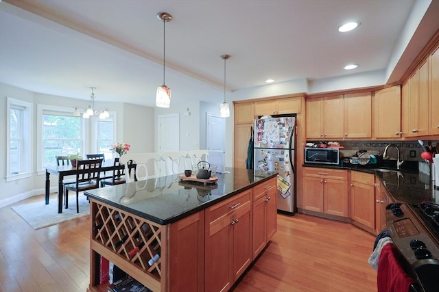 41 Webber St Unit 2, Malden, MA 02148 - kitchen with stainless steel appliances, light wood-style floors, decorative backsplash, dark stone countertops, and decorative light fixtures