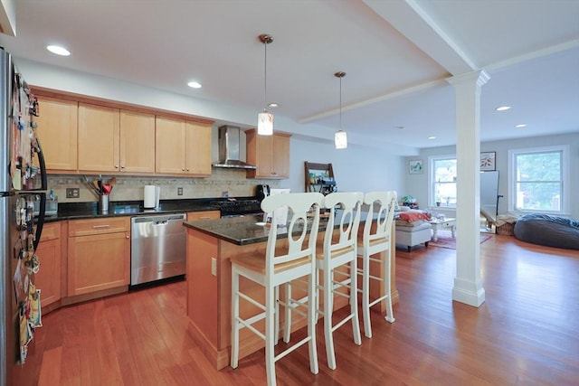 41 Webber St Unit 2, Malden, MA 02148 - kitchen featuring stainless steel appliances, wall chimney exhaust hood, decorative columns, light wood-style flooring, and a kitchen breakfast bar