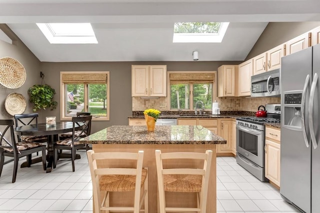 3 Dogwood Cir Unit 3, Franklin, MA 02038 - kitchen featuring a skylight, stainless steel appliances, vaulted ceiling, a sink, and tasteful backsplash