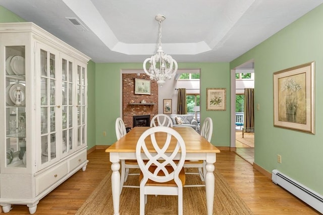 3 Dogwood Cir Unit 3, Franklin, MA 02038 - dining room with a baseboard radiator, light wood-style flooring, a chandelier, a raised ceiling, and a brick fireplace
