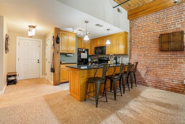14 Sanford St Unit 21, Medway, MA 02053 - kitchen with black appliances, brick wall, light colored carpet, dark countertops, and a peninsula