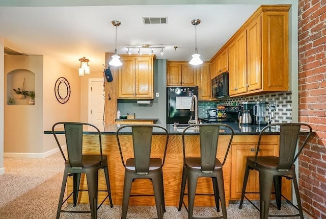 14 Sanford St Unit 21, Medway, MA 02053 - kitchen with black microwave, freestanding refrigerator, a kitchen breakfast bar, baseboards, and a peninsula
