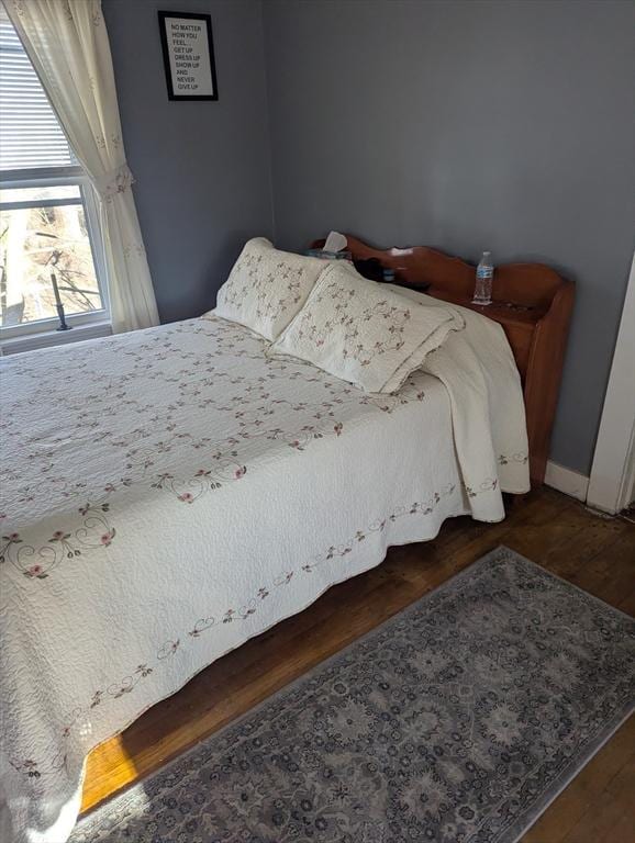 bedroom with dark hardwood / wood-style flooring