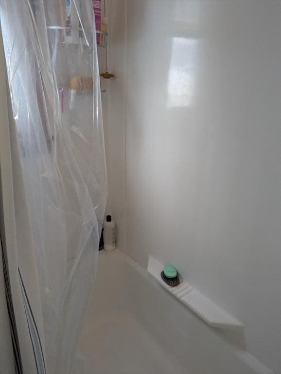 interior space with shower / tub combo with curtain