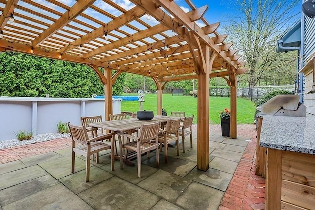 view of patio / terrace featuring exterior kitchen, a pergola, a fenced backyard, and outdoor dining space