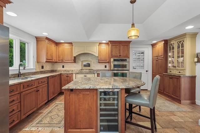 kitchen with wine cooler, a breakfast bar area, a sink, a kitchen island, and appliances with stainless steel finishes