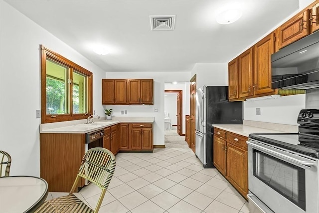22 Grove Pl Unit 4, Winchester, MA 01890 - kitchen featuring appliances with stainless steel finishes, light countertops, and brown cabinetry