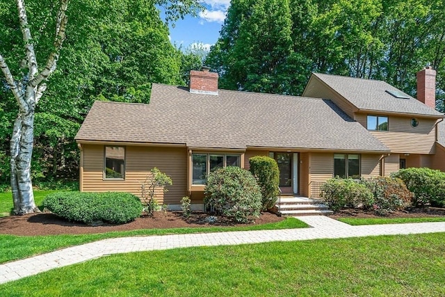 22 Grove Pl Unit 4, Winchester, MA 01890 - view of front of house with a front yard, a chimney, and a shingled roof