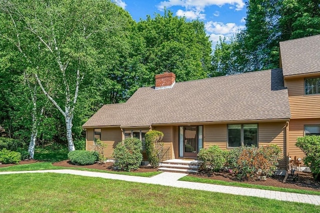 22 Grove Pl Unit 4, Winchester, MA 01890 - view of front of house with a front lawn, a chimney, and roof with shingles