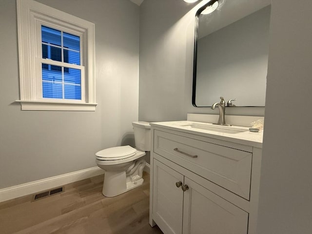 24 Cooper Rd, Webster, MA 01570 - half bathroom with wood finished floors, vanity, baseboards, and toilet