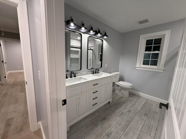 24 Cooper Rd, Webster, MA 01570 - full bathroom with wood finished floors, double vanity, baseboards, and toilet