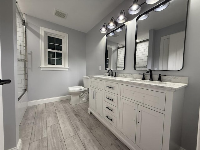 24 Cooper Rd, Webster, MA 01570 - full bathroom featuring baseboards, double vanity, toilet,  shower combination, and wood finished floors