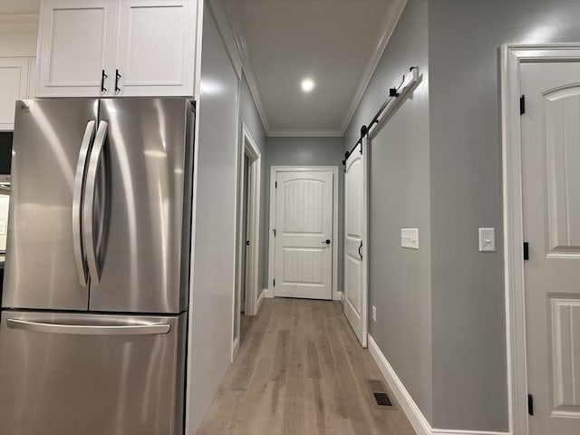 24 Cooper Rd, Webster, MA 01570 - kitchen featuring freestanding refrigerator, light wood-style floors, white cabinetry, ornamental molding, and a barn door