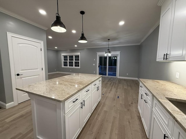 24 Cooper Rd, Webster, MA 01570 - kitchen with light wood-style floors, ornamental molding, white cabinets, pendant lighting, and light stone counters