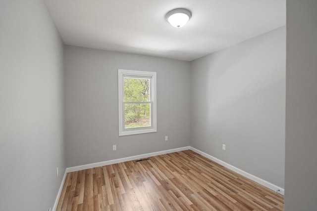 empty room featuring baseboards and light wood finished floors