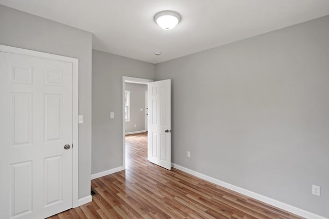 empty room with baseboards and wood finished floors