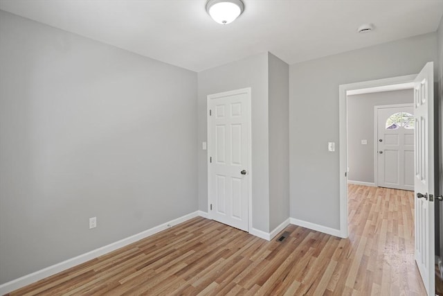 unfurnished room with light wood-style floors and baseboards