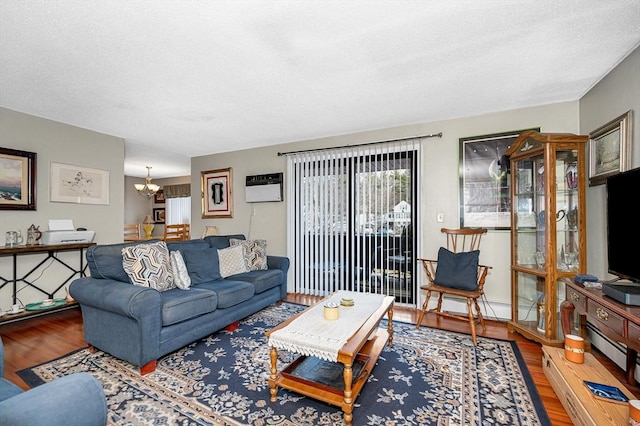 living room with wood-type flooring, a notable chandelier, and a wall mounted AC