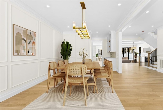 dining room featuring a notable chandelier, crown molding, and light wood-type flooring