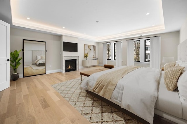 bedroom featuring light hardwood / wood-style flooring and a tray ceiling