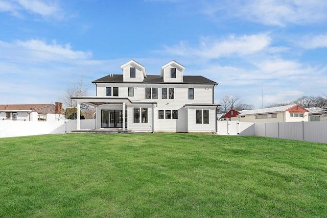 rear view of house with a patio and a lawn