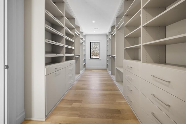 walk in closet with light hardwood / wood-style floors