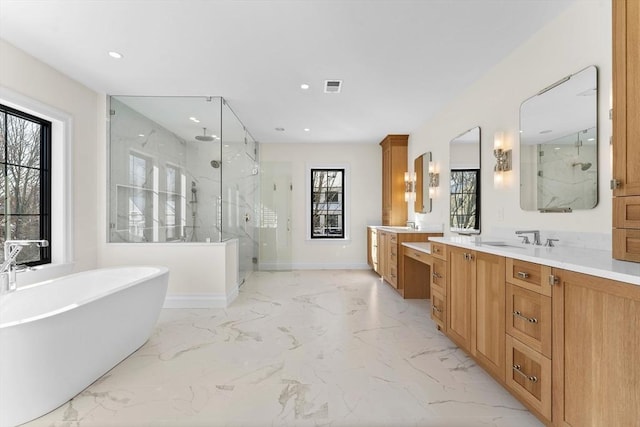 bathroom featuring a healthy amount of sunlight, independent shower and bath, and vanity