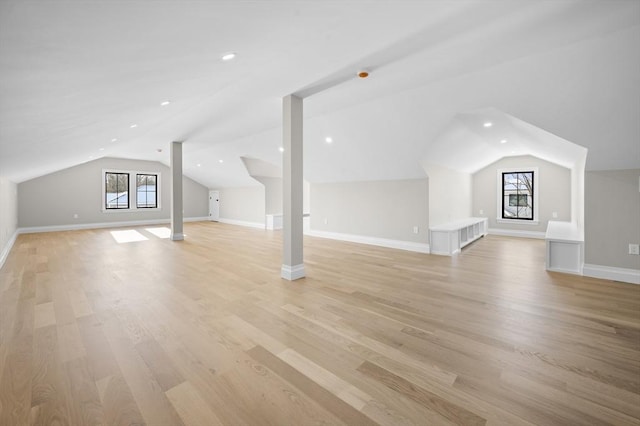 additional living space with lofted ceiling and light hardwood / wood-style flooring