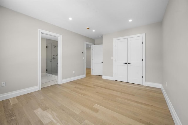 unfurnished bedroom with a closet, connected bathroom, and light hardwood / wood-style flooring