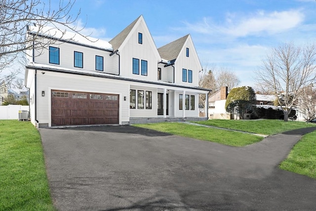 view of front of home featuring a garage, central AC, and a front yard