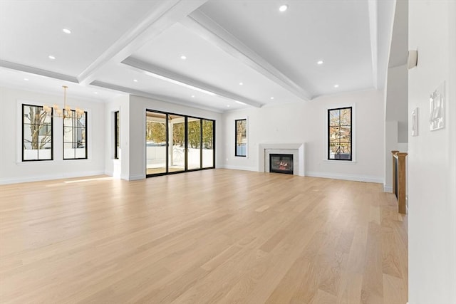 unfurnished living room featuring light hardwood / wood-style floors, a chandelier, and beamed ceiling