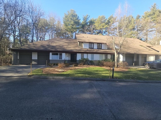 view of front of house with a garage and a front lawn