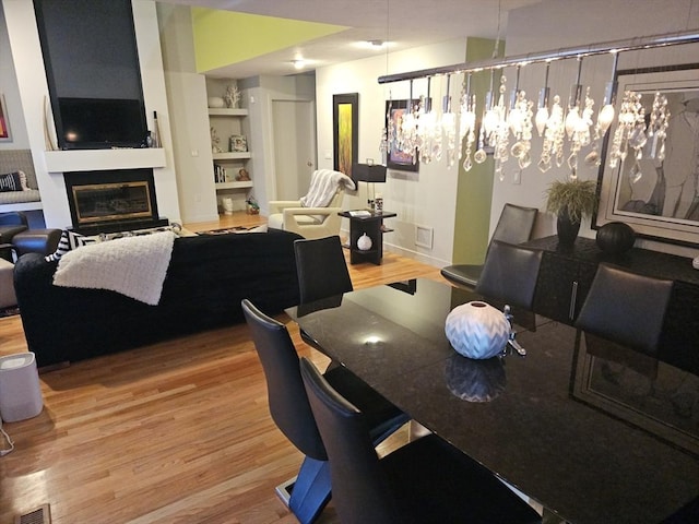 dining area featuring hardwood / wood-style flooring and built in shelves