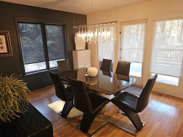 dining room with an inviting chandelier and wood-type flooring