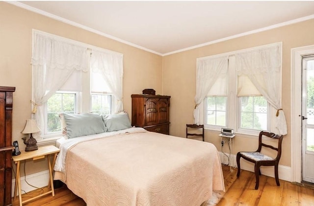 bedroom featuring light wood-style flooring, multiple windows, and crown molding