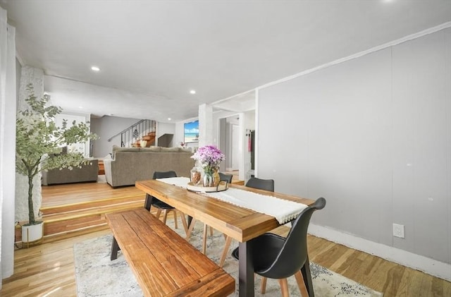 dining room featuring light wood finished floors, stairs, baseboards, and recessed lighting