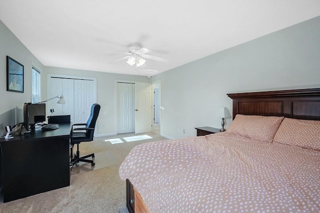 carpeted bedroom featuring two closets and ceiling fan